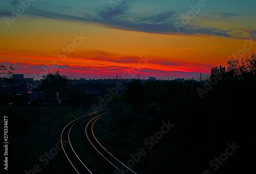 Railroad leaving into the distance on a background of red sunset