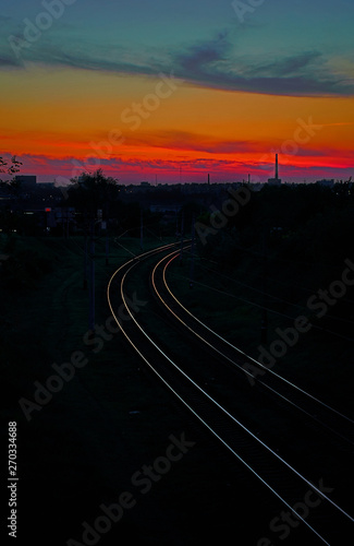 Railroad leaving into the distance on a background of red sunset