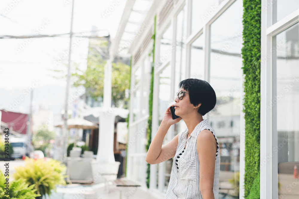 Asian woman sit and talk on cellphone Asian woman sit and talk on cellphone