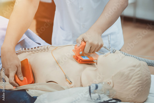 Obraz na plátně hands of doctor holding defibrillator electrods, performing defibrillation or el