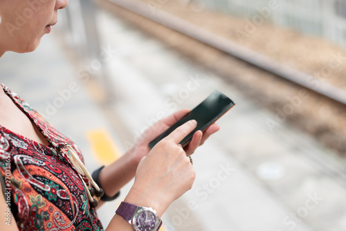 mature traveling woman waiting and using a cellphone