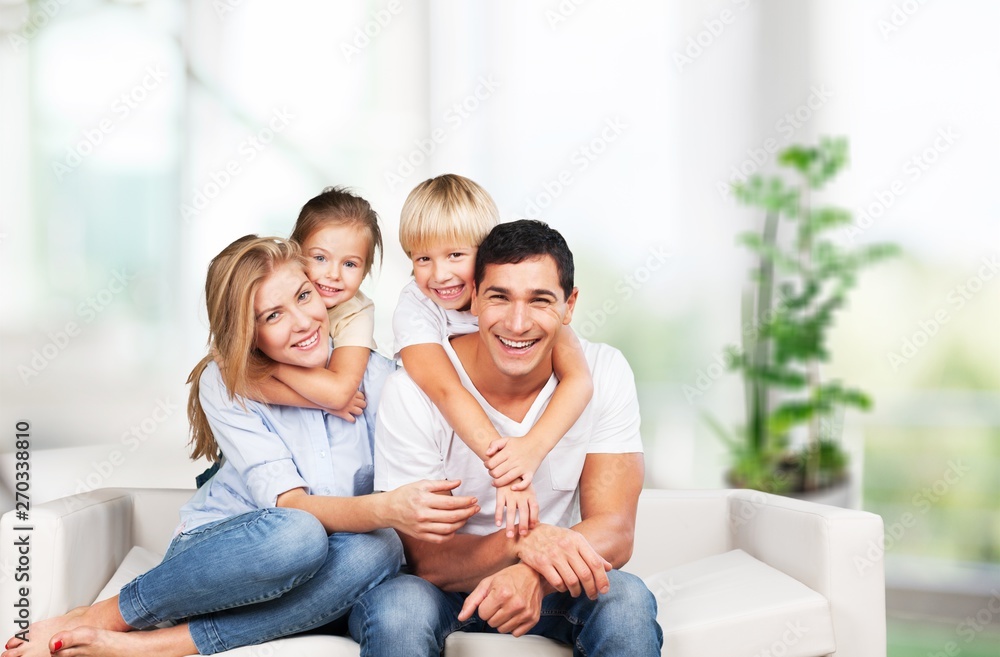 Beautiful smiling family sitting at sofa at home Beautiful smiling family sitting at sofa at home