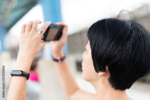 mature Asian woman using digital camera photo