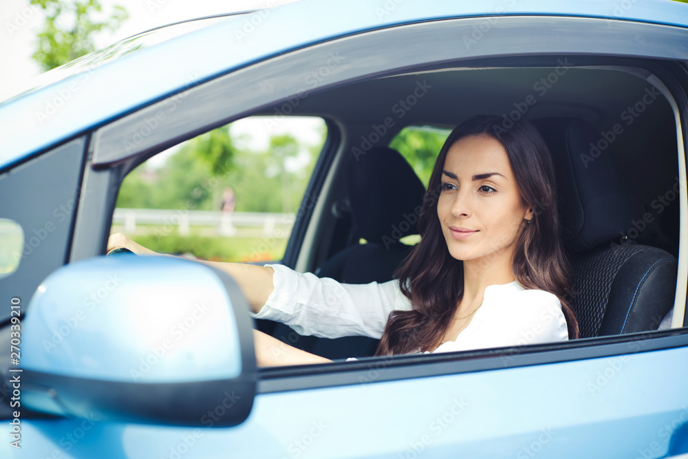 Cute young success happy brunette woman is driving a car. After dealership. Work auto. Vehicle of future Cute young success happy brunette woman is driving a car. After dealership. Work auto. Vehicle of future