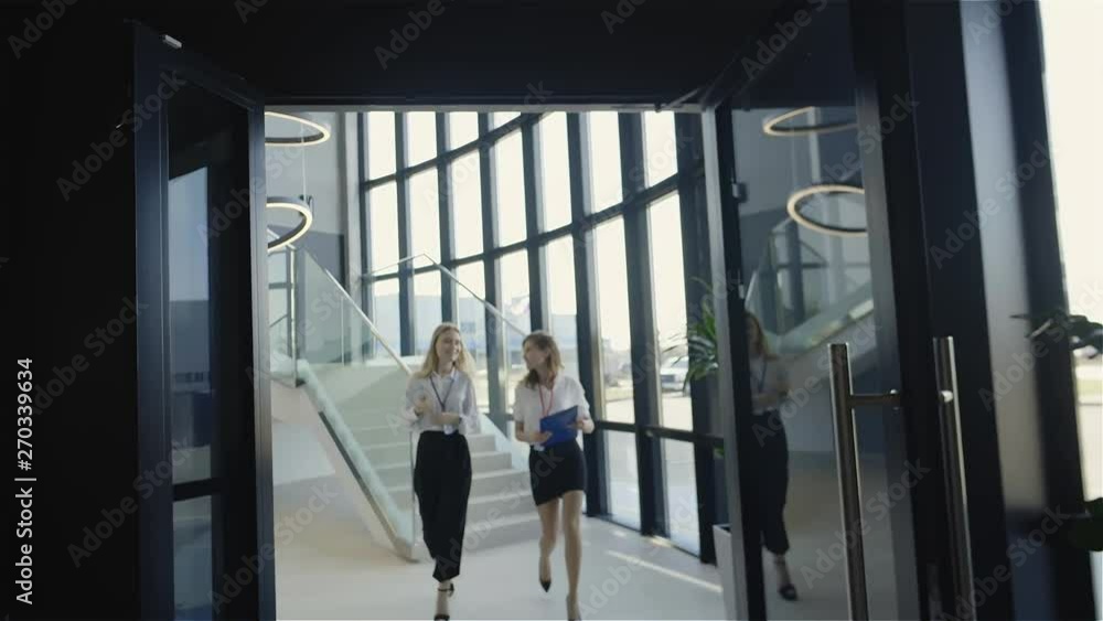 Female colleagues discussing job while walking Female colleagues discussing job while walking