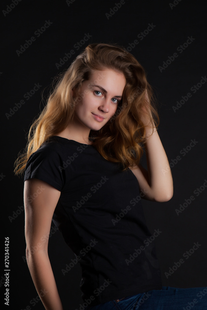 closeup portrait of a young, beautiful woman on a black background