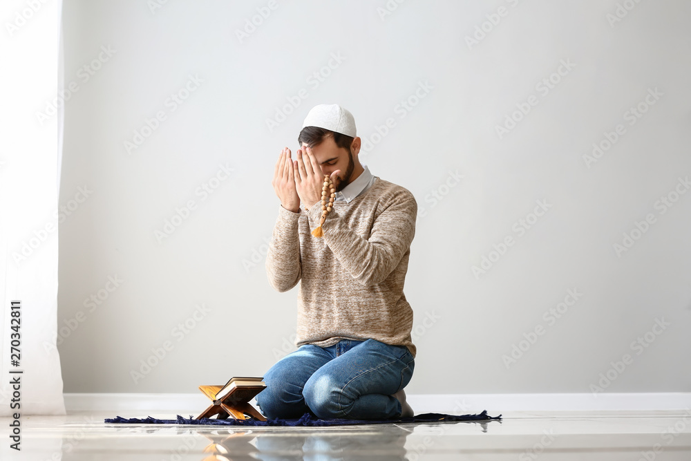Young Muslim man praying indoors Young Muslim man praying indoors