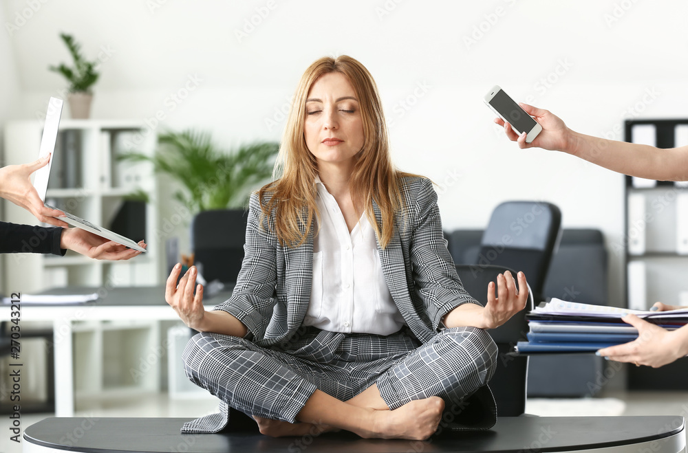 Mature businesswoman with a lot of work meditating in office - obrazy, fototapety, plakaty 