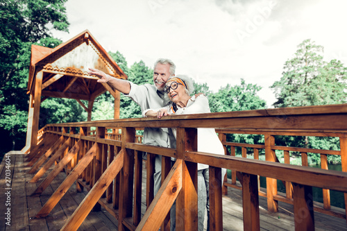 Happy couple standing on bridge and enjoying the nature scenery