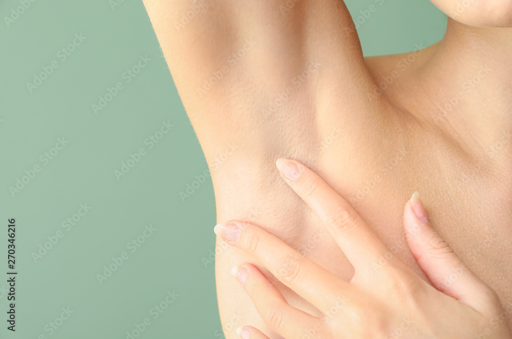 Fototapeta premium Beautiful young woman after laser hair removal procedure on color background