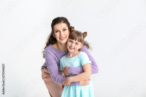 Happy mother with little adopted girl on white background