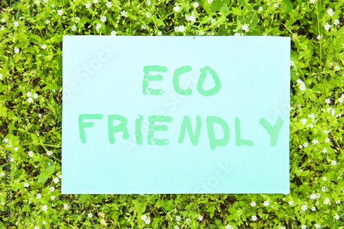 Sheet of paper with text ECO FRIENDLY outdoors © Pixel-Shot