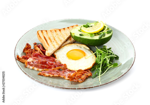 Plate with tasty fried egg, bacon, avocado and toasts on white background