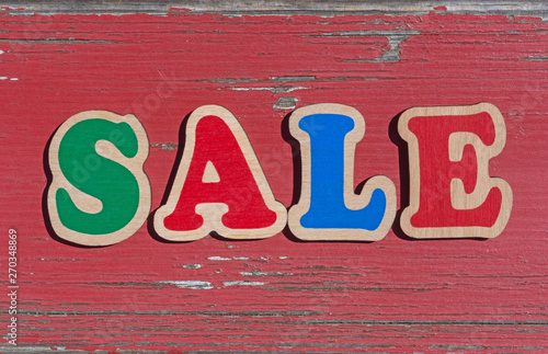 word sale made of wooden letters on old red board