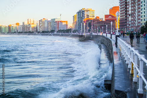 Wallpaper Mural Waves splashing against the wall in San Lorenzo beach in Gijon, Asturias, Spain, with the promenade and buildings in one side Torontodigital.ca