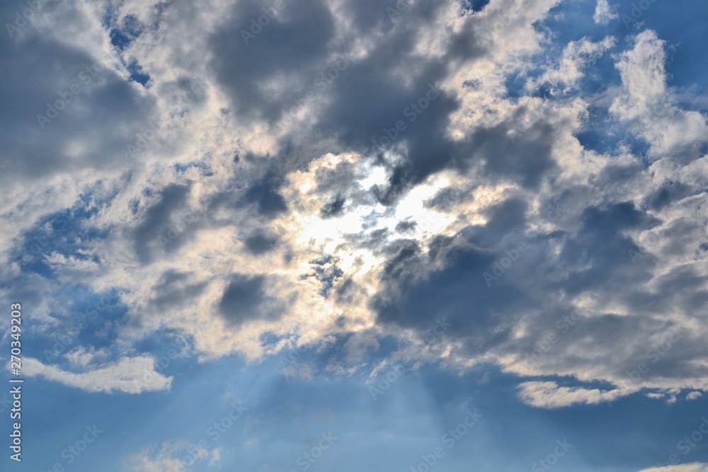 Sunbeam piercing through the clouds. Rays of sunshine breaks through the dark clouds. Faith symbol. Hope, faith, optimism concept Sunbeam piercing through the clouds. Rays of sunshine breaks through the dark clouds. Faith symbol. Hope, faith, optimism concept