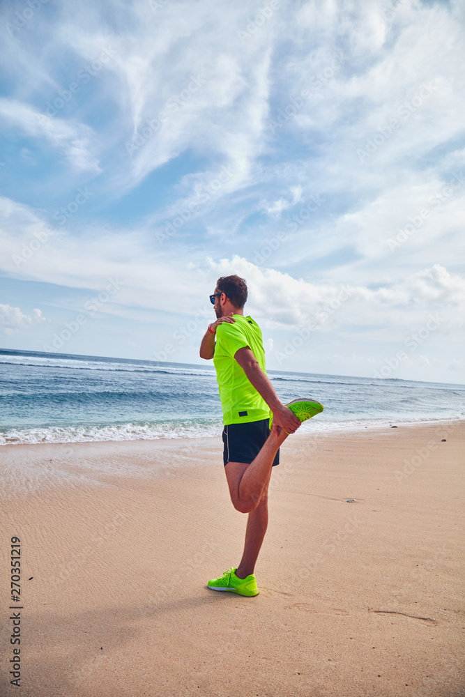 Sportsman stretching on a tropical sandy beach. Sportsman stretching on a tropical sandy beach.