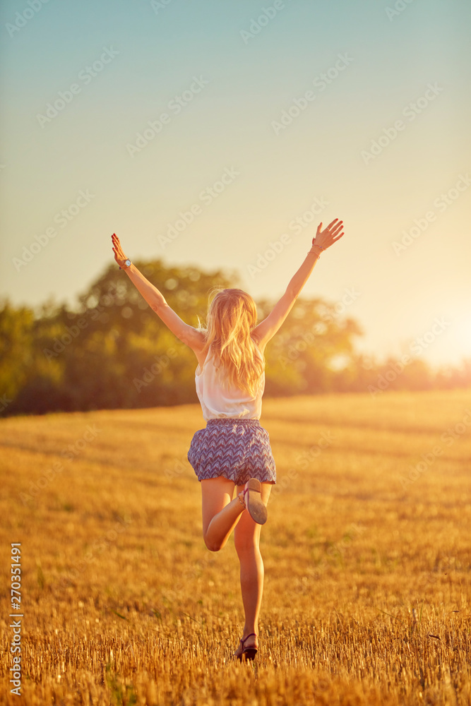 Young woman jumping and running in a wheat field. Young woman jumping and running in a wheat field.