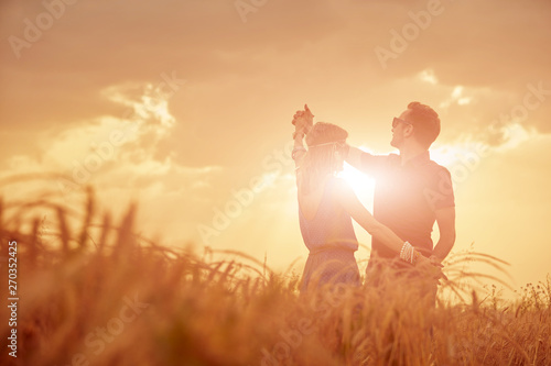 Couple in sunset   sunrise time in a wheat field.
