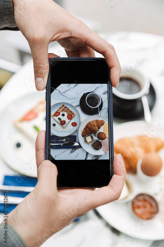 Close up of a woman taking photo of breakfast