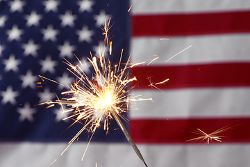Sparkler against USA flag. Independence Day celebration