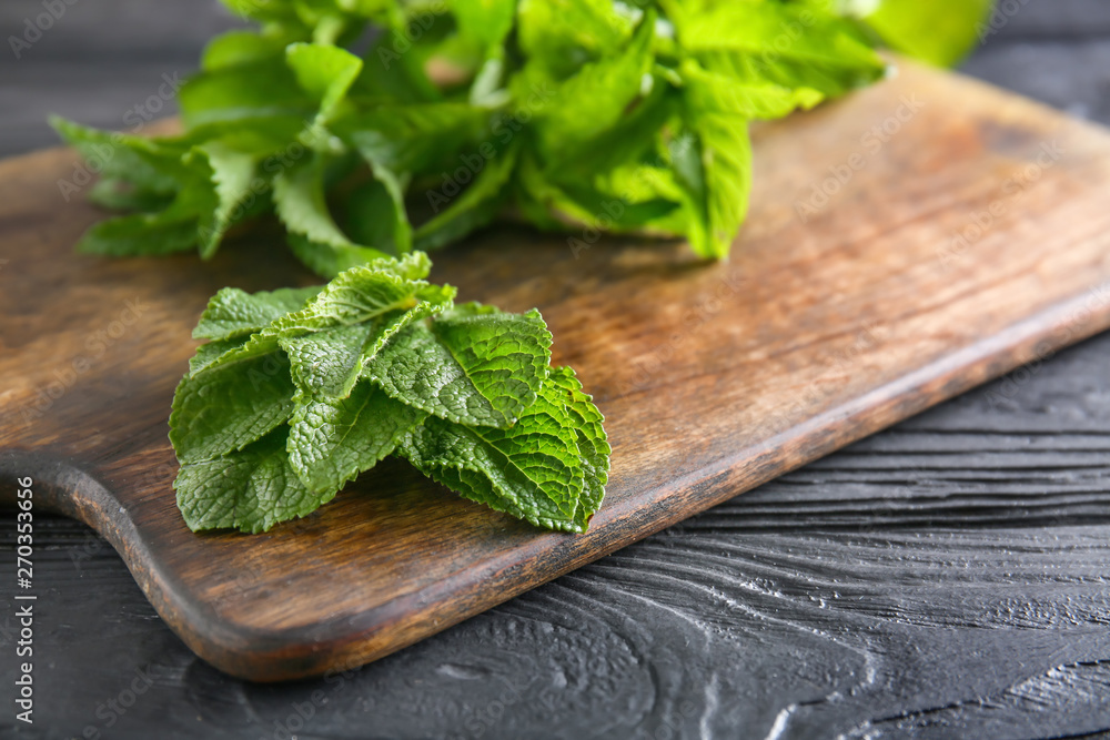 Board with green mint on wooden background, closeup Board with green mint on wooden background, closeup