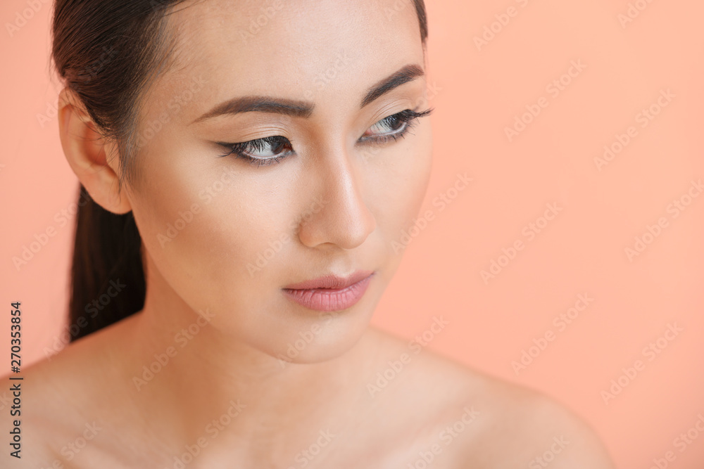 Asian woman with beautiful makeup on color background