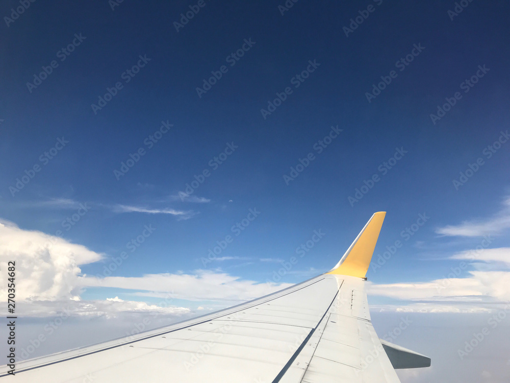 Beautiful of Blue sky above the clouds with wings of the airplane. View of Looking through the window of airplane. Beautiful of Blue sky above the clouds with wings of the airplane. View of Looking through the window of airplane.