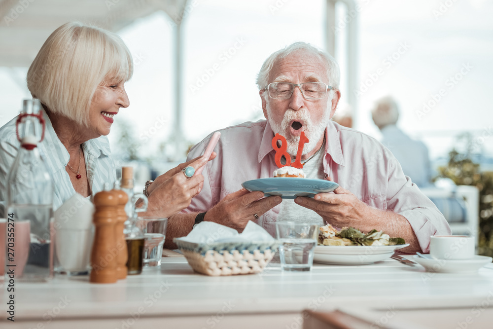 Attentive senior male person staring at candles Attentive senior male person staring at candles