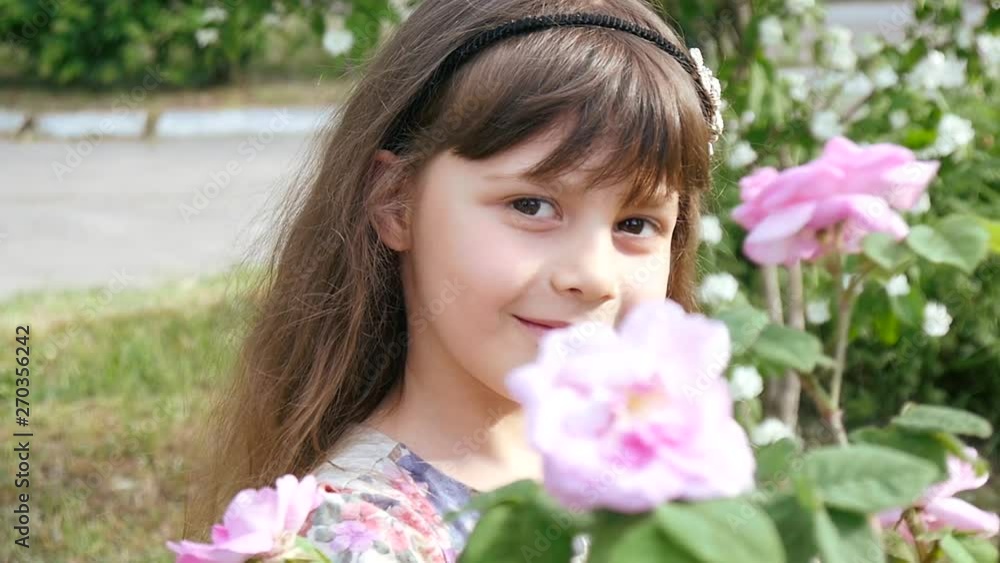 Cute little Girl pretty Face Portrait with blooming Roses in a Summer Park Cute little Girl pretty Face Portrait with blooming Roses in a Summer Park