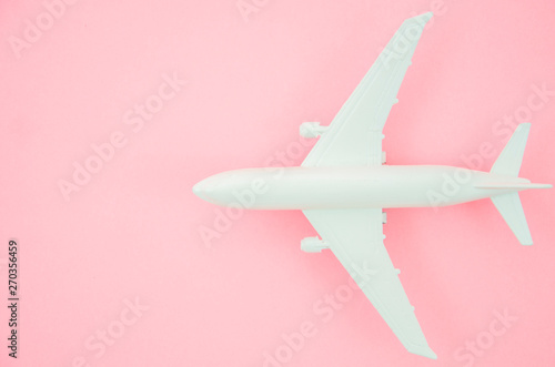 Top view model plane, close up airplane on pink pastel background. Flat lay with copy space for travel banner