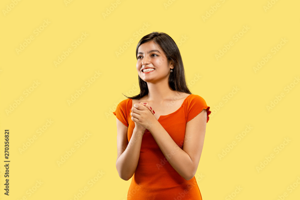 Beautiful female half-length portrait isolated on yellow studio background. Young emotional indian woman in dress astonished and happy. Negative space. Facial expression, human emotions concept. Beautiful female half-length portrait isolated on yellow studio background. Young emotional indian woman in dress astonished and happy. Negative space. Facial expression, human emotions concept.