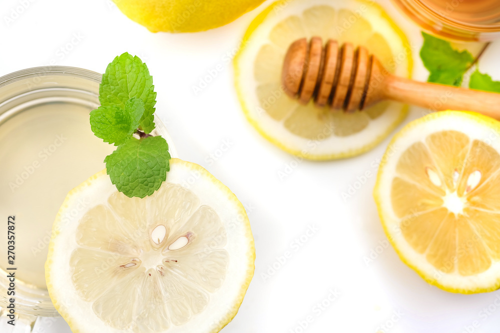 Honey dipper stick and Yellow Lemon citrus half slices with leaf on white background Honey dipper stick and Yellow Lemon citrus half slices with leaf on white background
