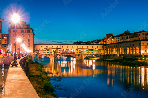 Fantastic evening cityscape of Florence with Old Palace (Palazzo Vecchio or Palazzo della Signoria) on background and Ponte Vecchio bridge over Arno river. Colorful night scene of Italy, Europe. © Andrew Mayovskyy