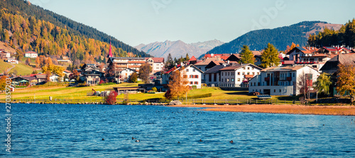 Panoramic autumn view of San Valentin village. Colorful morning scene of small Italian village located on shore of Muta lake, South Tyrol, Italy, Europe. Beauty of countryside concept background.