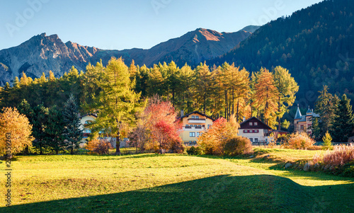 Colorful autumn view of San Valentin village. Beautufel morning scene of small Italian village located on shore of Muta lake, South Tyrol, Italy, Europe. Beauty of countryside concept background.