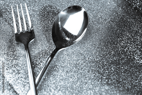 Silver or platinum spoon on glitter silver dust background ,Luxury and elegant concept photo