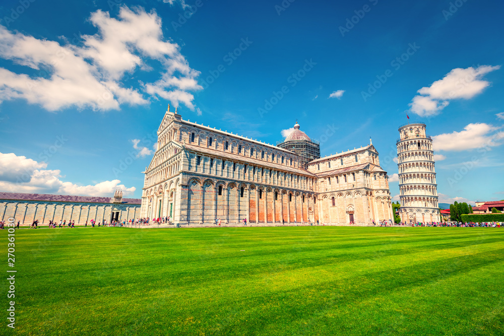 Captivating spring view of famous Leaning Tower in Pisa. Sunny morning scene with hundreds of tourists in Piazza dei Miracoli (Square of Miracles), Italy, Europe. Traveling concept background.