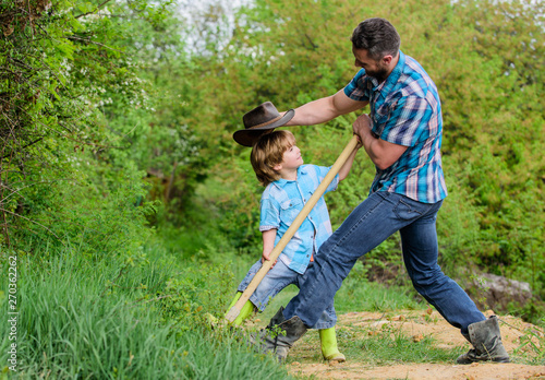 Cute child in nature having fun cowboy dad. Find treasures. Little boy and father with shovel looking for treasures. Spirit of adventures. Adventure hunting for treasures. Little helper in garden © be free