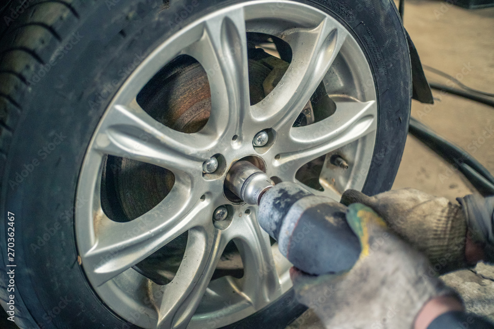 Unscrew the hub in the wheel of the car. Car repair in car service