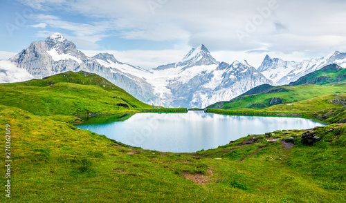 Splendid summer view of the Bachalpsee lake with Schreckhorn peak on background. Colorful morning scene of Swiss Bernese Alps, Switzerland, Europe. Beauty of nature concept background.