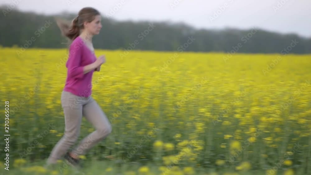 Young woman running in blooming fields. Young woman running in blooming fields.