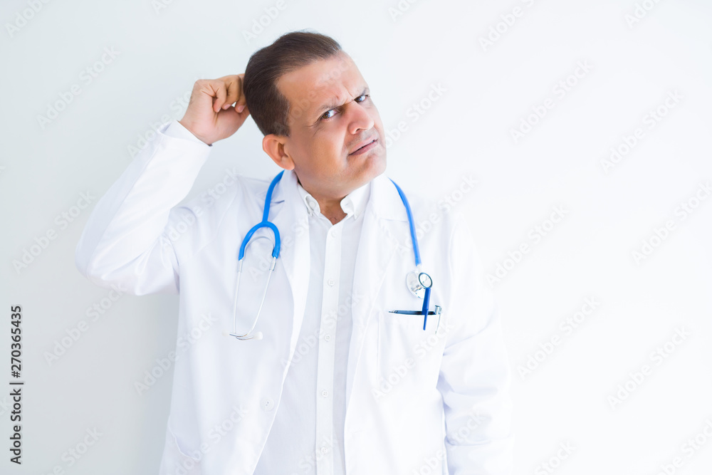 Middle age doctor man wearing stethoscope and medical coat over white background confuse and wonder about question. Uncertain with doubt, thinking with hand on head. Pensive concept. Middle age doctor man wearing stethoscope and medical coat over white background confuse and wonder about question. Uncertain with doubt, thinking with hand on head. Pensive concept.