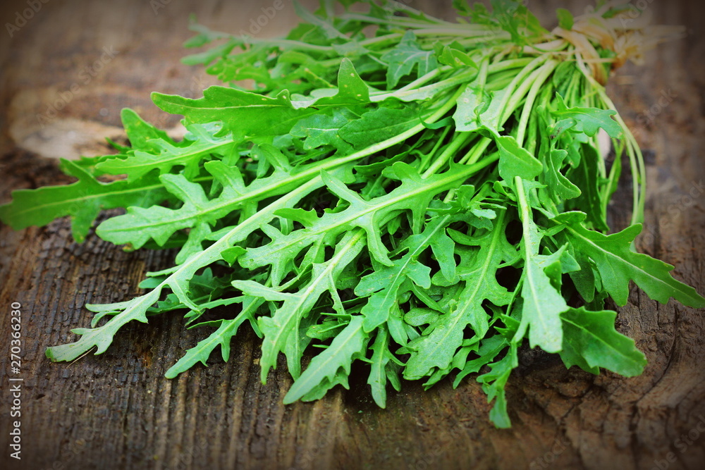 Fresh green arugula leaves on wooden rustic background . Rocket salad or rucola, healthy food, diet. Nutrition concept Fresh green arugula leaves on wooden rustic background . Rocket salad or rucola, healthy food, diet. Nutrition concept