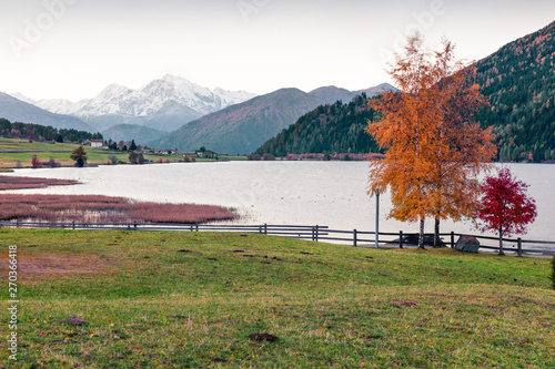 Fabulous autumn sunrise view of Haidersee (Lago della Muta) lake with Ortler peak on background. Splendid morning scene of Italian Alps, Italy, Europe. Beauty of countryside concept background.