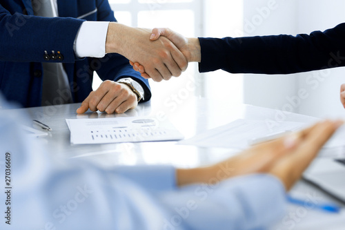 Business people shaking hands finishing up a meeting , close-up. Success at negotiation and handshake concepts. Group of lawyers at work