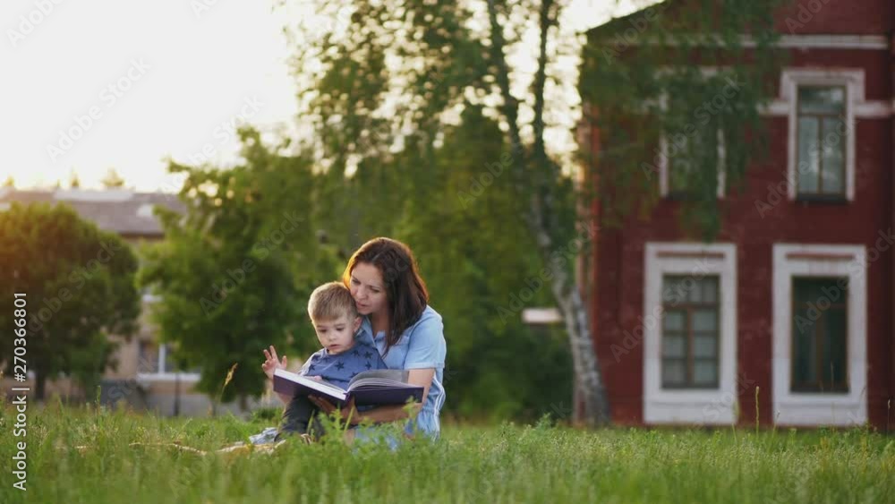 Mother reads a book to her little son Mother reads a book to her little son
