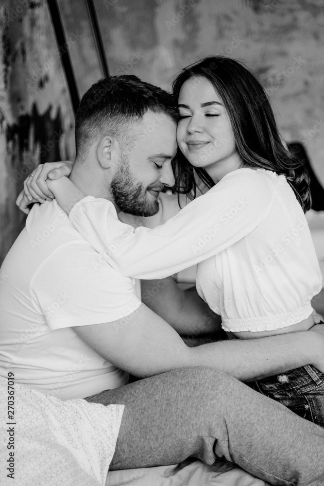 Couple in love in the bedroom. Slender brunette. Stylish interior. Couple in love in the bedroom. Slender brunette. Stylish interior.