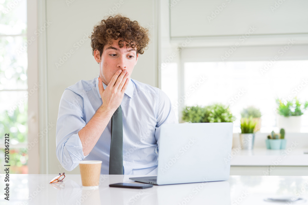 Young business man working with computer laptop at the office cover mouth with hand shocked with shame for mistake, expression of fear, scared in silence, secret concept Young business man working with computer laptop at the office cover mouth with hand shocked with shame for mistake, expression of fear, scared in silence, secret concept
