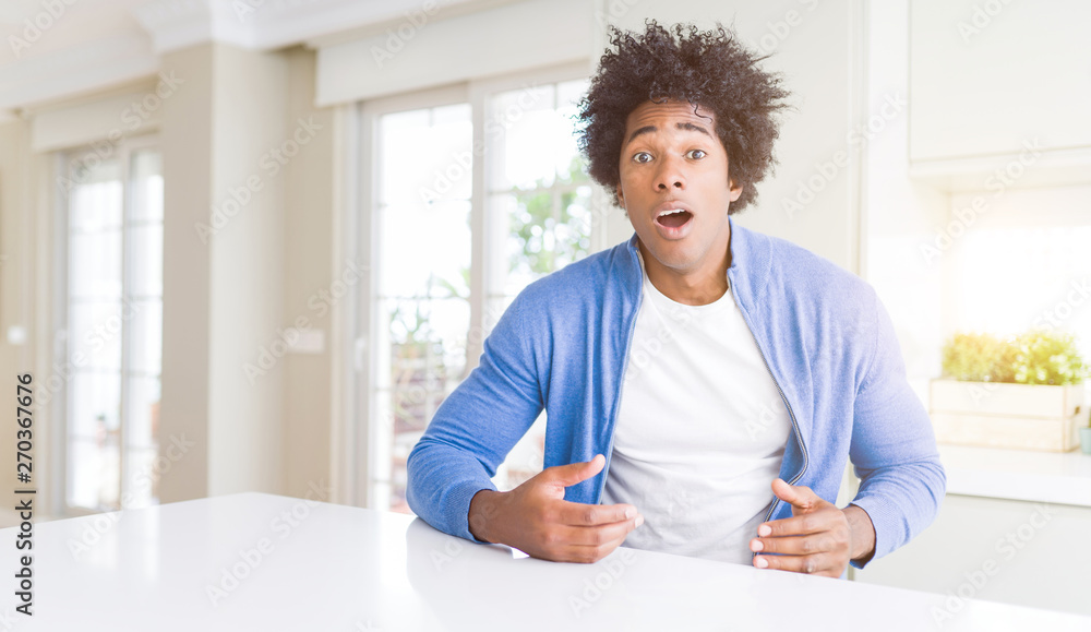 African American man at home afraid and shocked with surprise expression, fear and excited face.